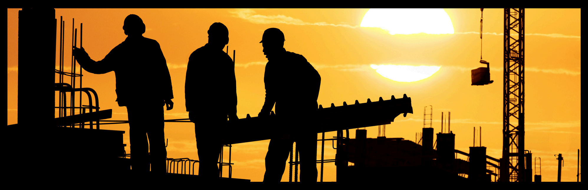 Construction site silhouetted at sunset